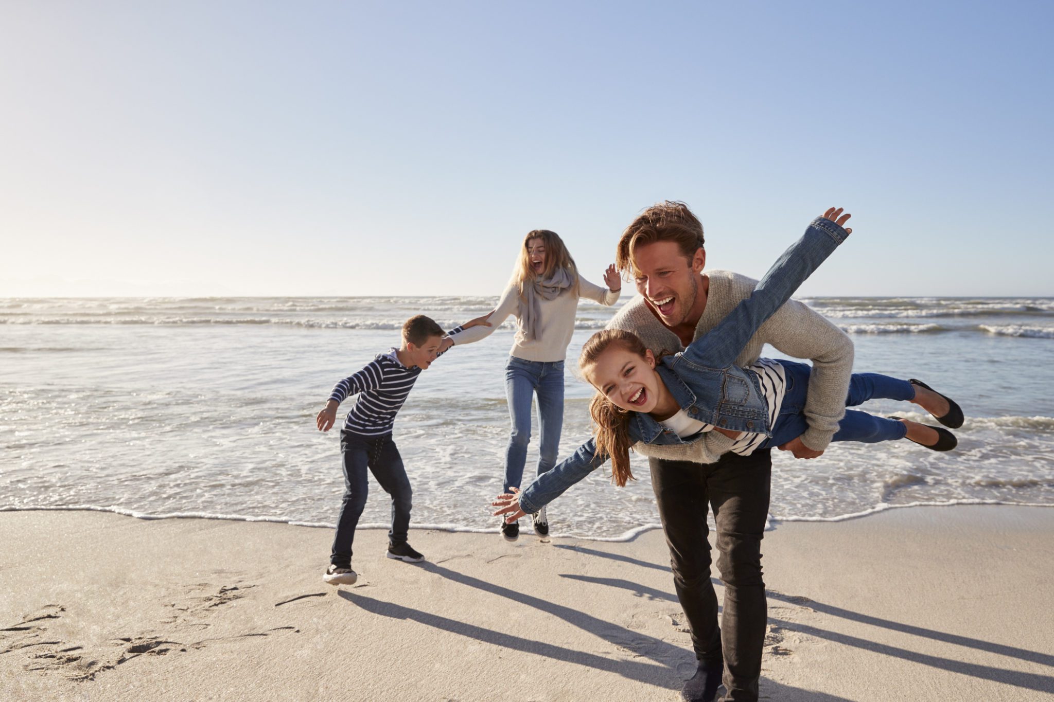 Parents With Children Having Fun On Winter Beach Together, one of the most fun things to do in Myrtle Beach in the winter.