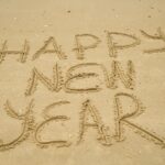 Happy New Year written in the sand at the beach.