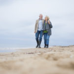 Older couple walking on the beach.
