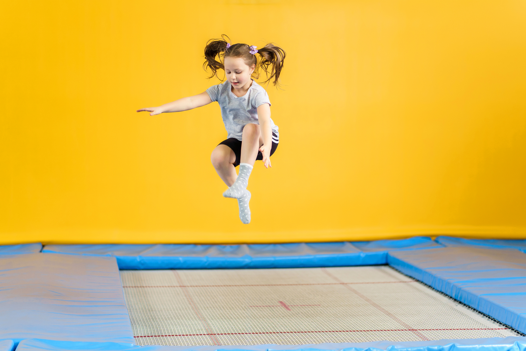 Happy little girl jumping on a trampoline at a trampoline park.